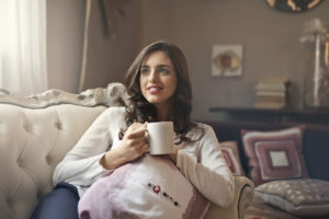 Bella ragazza si rilassa a casa bevendo una tazza di te